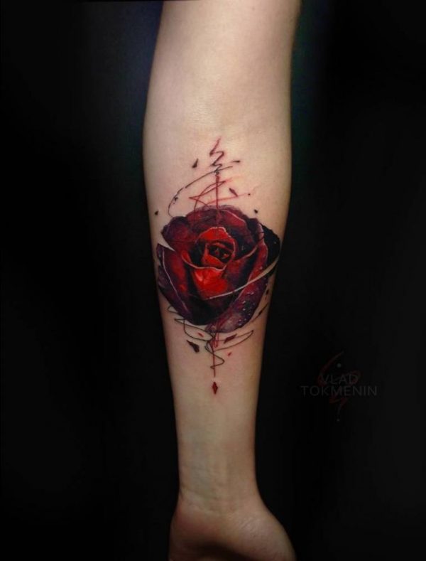 Vaquera con tinta negra y tatuaje de rosa roja en el brazo